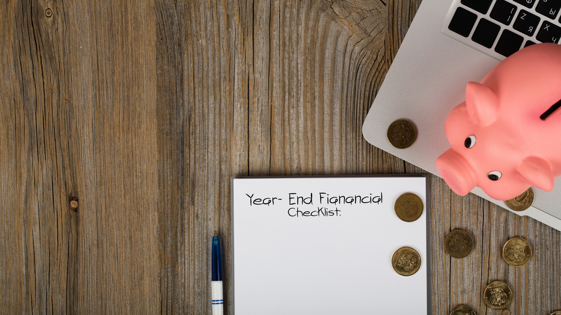 year end financial checklist next to a laptop and small bank